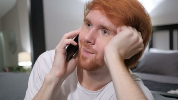 Raslantı Smartphone'da konuşan Kızıl saçlı adam oturuyor — Stok video