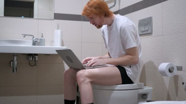 Reaktion auf Versagen bei der Arbeit am Laptop in der Toilette — Stockvideo