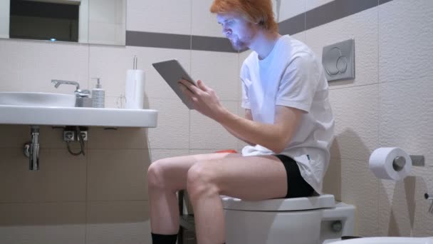 Uomo che reagisce al fallimento sul PC Tablet in WC, Commode — Video Stock