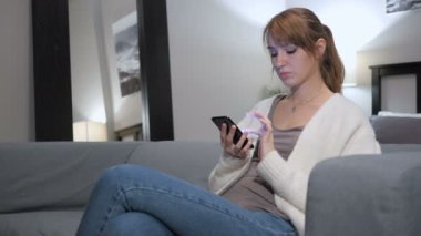 Kadın kanepede oturan smartphone cep telefonu ile Internet tarama