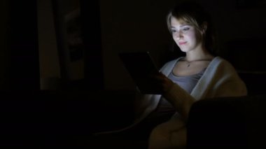 Geceleri tablet bilgisayar kullanan kadın