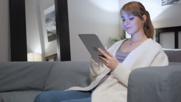 Nő a tábla-Pc, a fotelben ülve az interneten való böngészés — Stock videók