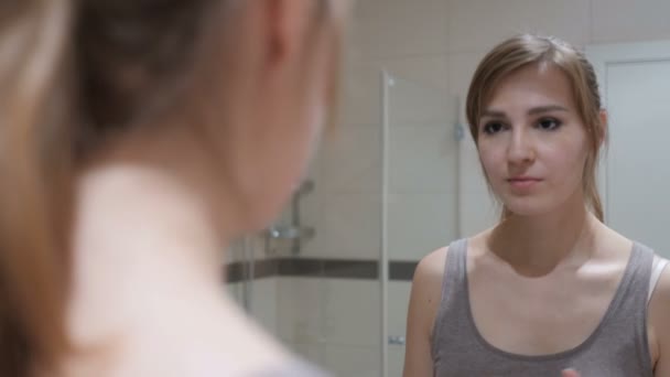 Νεαρή γυναίκα βάζει κραγιόν στα χείλη, καθρέφτης — Αρχείο Βίντεο