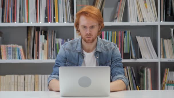 Sorprendido, aturdido hombre con cabellos rojos trabajando en el ordenador portátil — Vídeo de stock