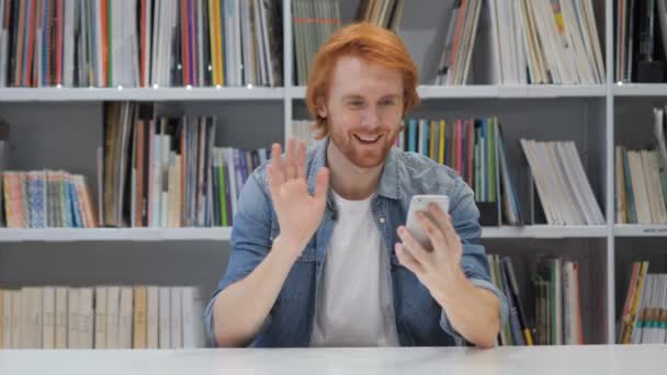 スマート フォンでオンライン ビデオ チャットでリラックス赤毛の男 — ストック動画