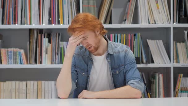 Mal de tête, Homme rousse tendu au travail au bureau, Bibliothèque — Video