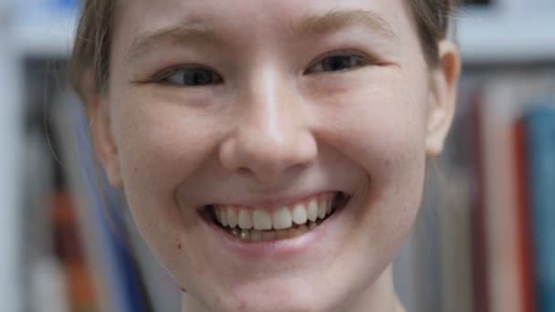 Primer plano del rostro femenino joven sonriente, interior — Vídeos de Stock