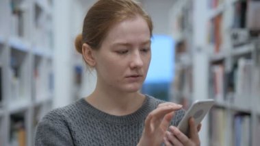 Online tarama için akıllı telefon kullanan genç kadın