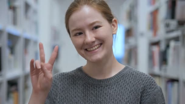 若い女性のカフェでの身振りで示す勝利のサインの肖像画 — ストック動画