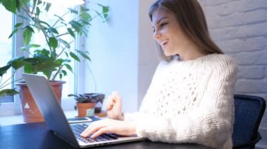 Web Video sohbet etmek üstünde Laptop ofisinde oturan genç erkek tarafından