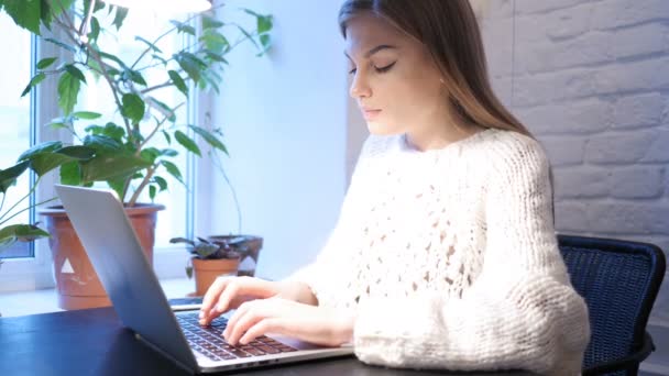 Mujer joven trabajando en el ordenador portátil en la oficina — Vídeos de Stock