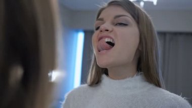 Genç kız ayna beyaz dişlerini kontrol