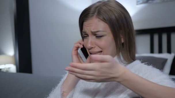 Chorando mulher falando no telefone, enquanto sentado no sofá — Vídeo de Stock