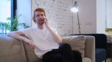 Telefon, kanepede oturan Kızıl saçlı tasarımcı konuşuyor