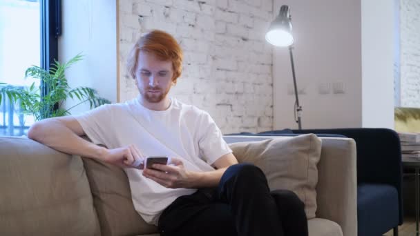 Kızıl saçlı tasarımcısı yaratıcı ofiste Smartphone kullanarak — Stok video