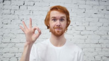 Ağır çekim Tamam işareti kırmızı tüyler olan adam tarafından
