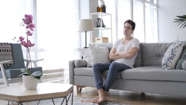 Ciddi rahatlatıcı adam oturuyor evde kanepe — Stok video