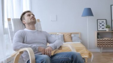 Dalgın yetişkin adam sandalyeye rahatlatıcı ve çatı arıyor