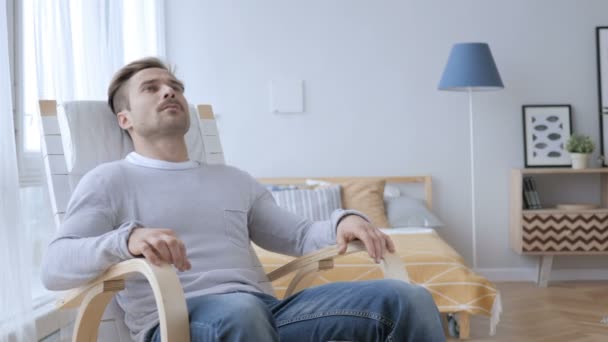 Homem adulto deixando a cadeira relaxante no quarto — Vídeo de Stock