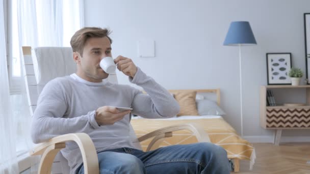 カジュアルな椅子に座ってコーヒーを飲む大人の男をリラックス — ストック動画