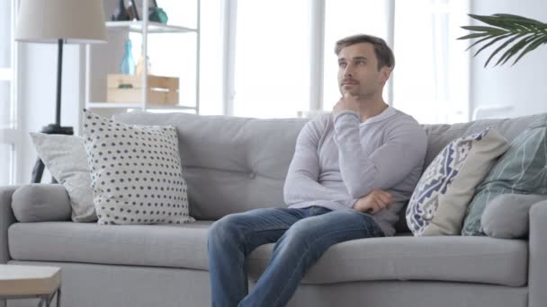 Myšlení zamyšlený dospělý muž sedící relaxovat na gauči — Stock video