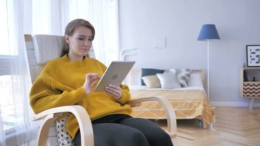 Casual üzerinde oturan adam tarama Internet Tablet üzerinde sandalye