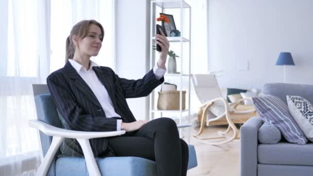 Женщина в офисе делает селфи на смартфоне — стоковое видео