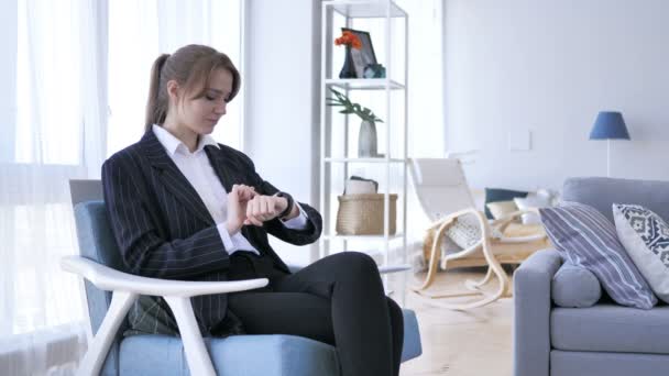 Γυναίκα χρησιμοποιώντας Smartwatch ενώ κάθεται στον καναπέ — Αρχείο Βίντεο
