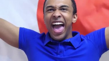 Japon Fan yavaş çekimde Japonya bayrağı tutarak kutluyor