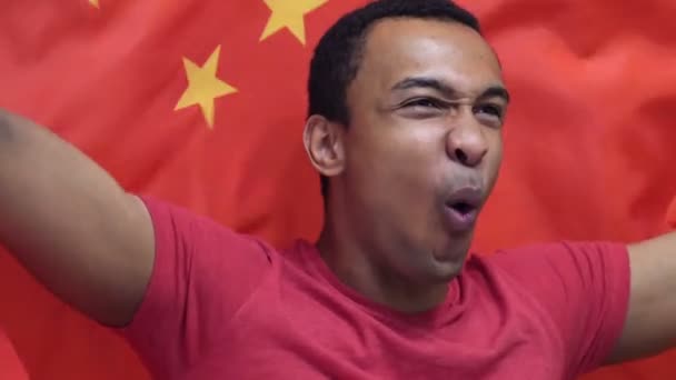 Chinesischer Fan feiert, während er die chinesische Flagge in Zeitlupe hält — Stockvideo