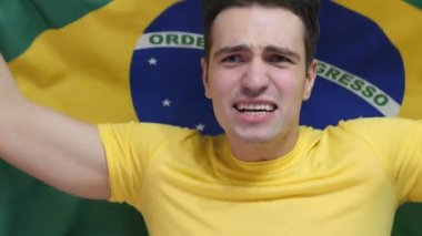 Brezilyalı genç adam ağır çekimde Brezilya bayrağı tutarak kutluyor