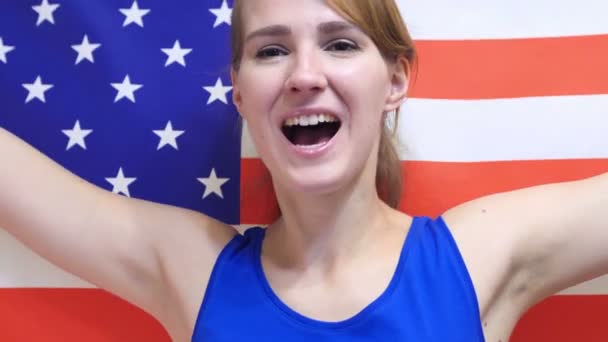 Amerikanische junge Frau feiert, während sie die Flagge Amerikas in Zeitlupe hält — Stockvideo