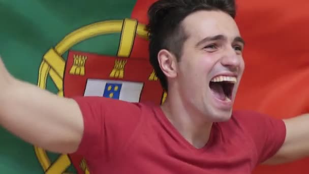 Portuguese Young Man celebrating while holding the flag of Portugal in Slow Motion