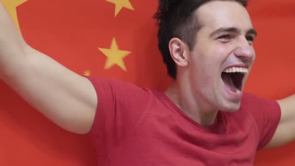 Jovem chinês comemorando enquanto segura a bandeira chinesa em câmera lenta — Vídeo de Stock