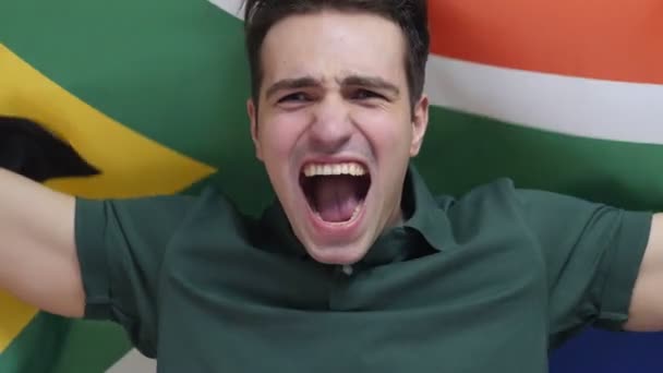 South African mladý muž slaví drží vlajku Jižní Afriky v pomalém pohybu — Stock video