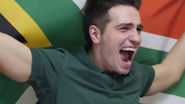 South African Young Man celebrating while holding the flag of South Africa in Slow Motion — Stock Video