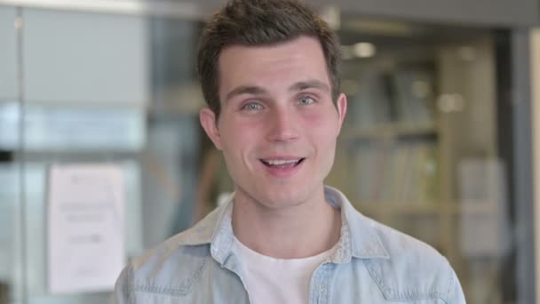 Retrato de un joven diseñador haciendo video chat y saludando — Vídeos de Stock