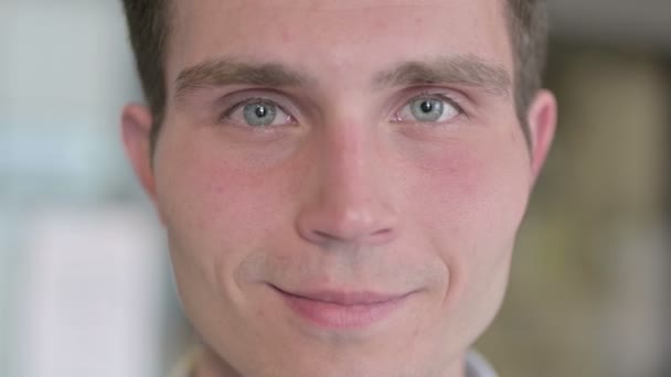 Nahaufnahme eines fröhlichen jungen Mannes, der in die Kamera lächelt — Stockvideo