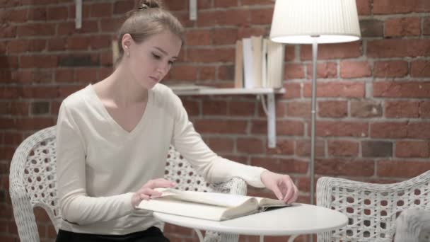 Young Woman Thinking and Reading Book at Home — Stock Video