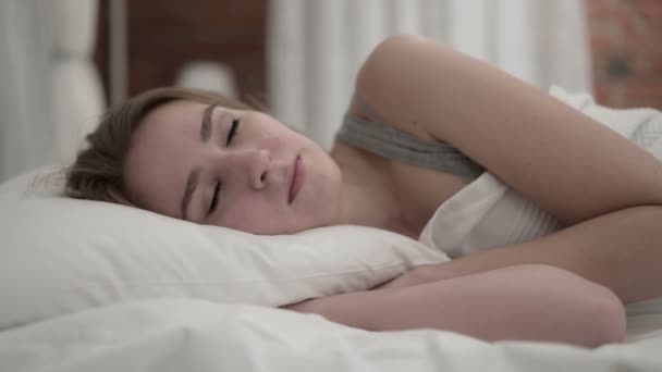 Aantrekkelijke jonge vrouw die wakker wordt en het bed verlaat — Stockvideo