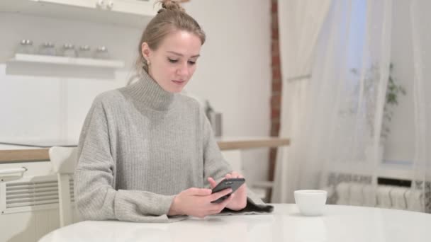 Attrayant jeune femme en utilisant le téléphone intelligent à la maison — Video