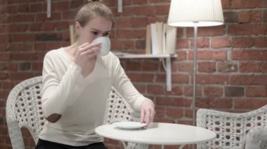 Kahve içmekten dişi ağrıyan genç bir kadın.