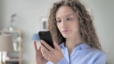 Kıvırcık saç kadın meşgul kullanarak Smartphone