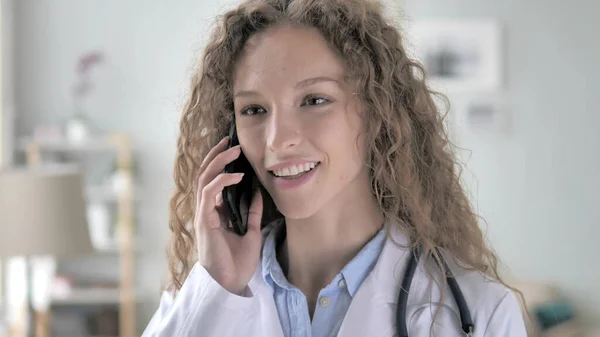 Ung dam läkare pratar med patienten på telefon — Stockfoto