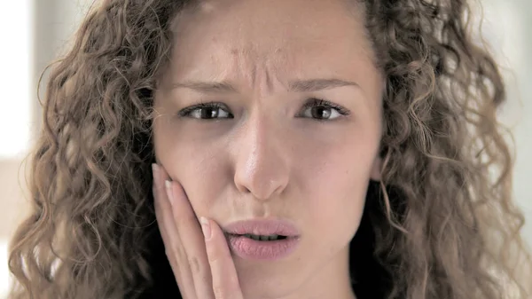 Diş ağrısı, dişi ağrı ile kıvırcık saçlı kadın yakın yukarı yüz — Stok fotoğraf