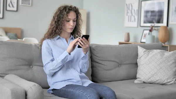 Opgewonden krullend haar vrouw met succes online winkelen op smartphone — Stockfoto