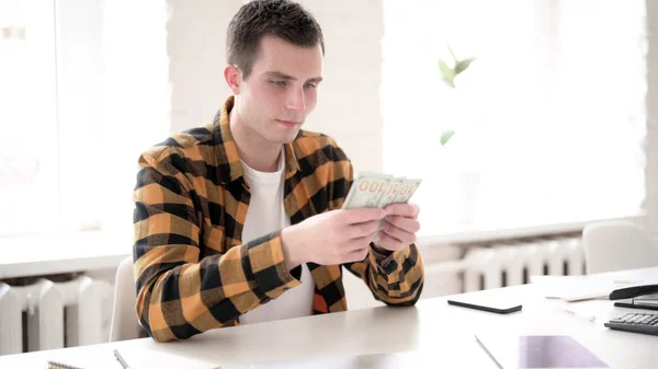 Casual ung man Counting dollar papper valuta — Stockfoto