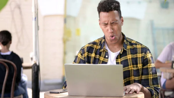 Homem Africano jovem se perguntando em choque no laptop, Café ao ar livre — Fotografia de Stock