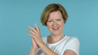 Mavi arka planda yalıtılmış alkışlamak yaşlı kadın tebrik