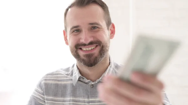 Hombre joven adulto que da moneda de papel dólar — Foto de Stock